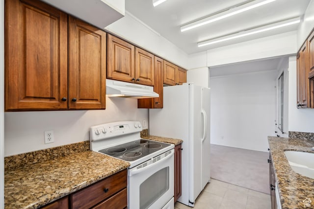 777 E S Temple N Unit 9J, Salt Lake City, UT 84102 - kitchen with white electric range, under cabinet range hood, brown cabinetry, light colored carpet, and light stone countertops