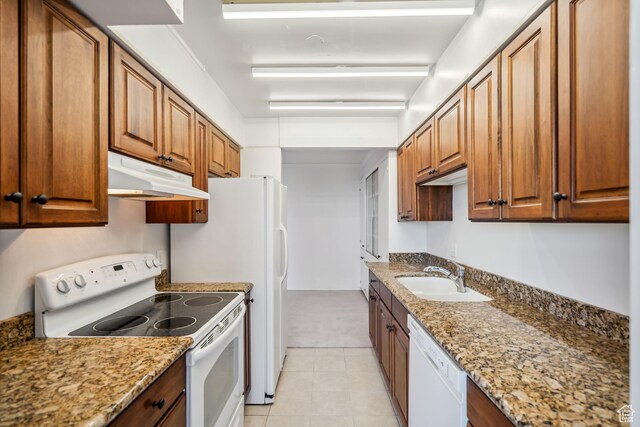 777 E S Temple N Unit 9J, Salt Lake City, UT 84102 - kitchen featuring white appliances, under cabinet range hood, brown cabinets, and light stone counters