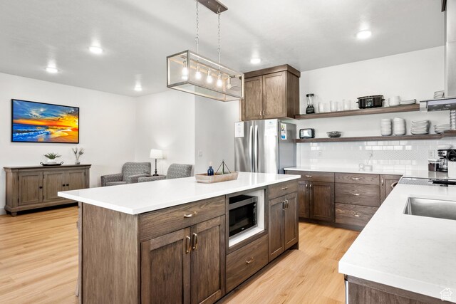 140 W 150 S Unit I34, Garden City, UT 84028 - kitchen with freestanding refrigerator, light wood-style floors, open shelves, light countertops, and tasteful backsplash