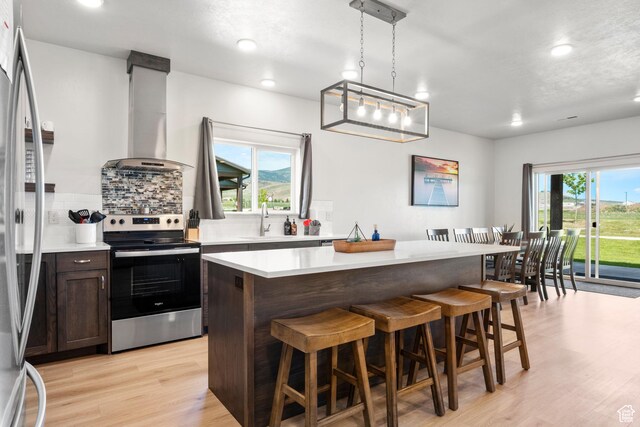 140 W 150 S Unit I34, Garden City, UT 84028 - kitchen featuring appliances with stainless steel finishes, range hood, backsplash, a breakfast bar area, and recessed lighting