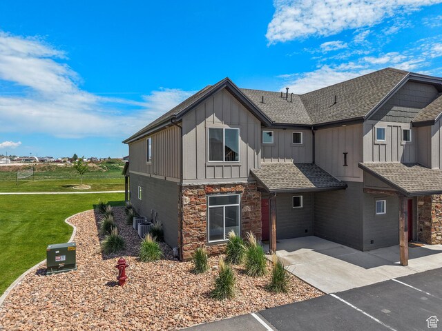 140 W 150 S Unit I34, Garden City, UT 84028 - view of front of home with board and batten siding, stone siding, a front yard, and roof with shingles
