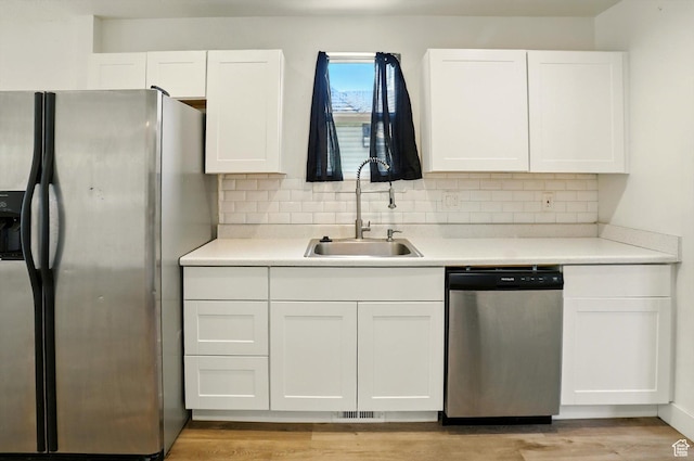 840 E 22nd St S, Ogden, UT 84401 - kitchen with stainless steel appliances, white cabinets, light wood finished floors, backsplash, and light countertops
