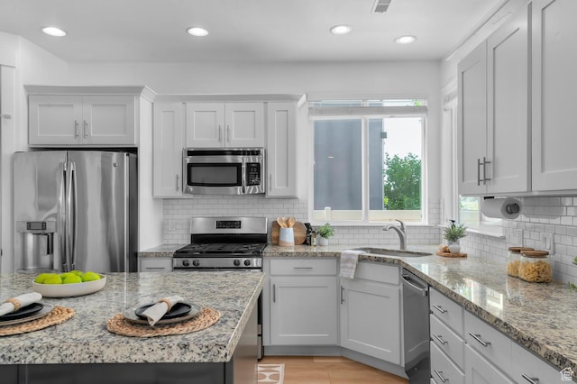 68 N Eden Way, Vineyard, UT 84059 - kitchen with stainless steel appliances, backsplash, light stone countertops, recessed lighting, and white cabinets