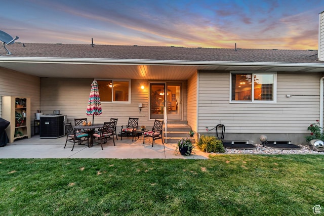 145 N 240 E, Orem, UT 84057 - back of property at dusk with a yard, a patio area, and a shingled roof
