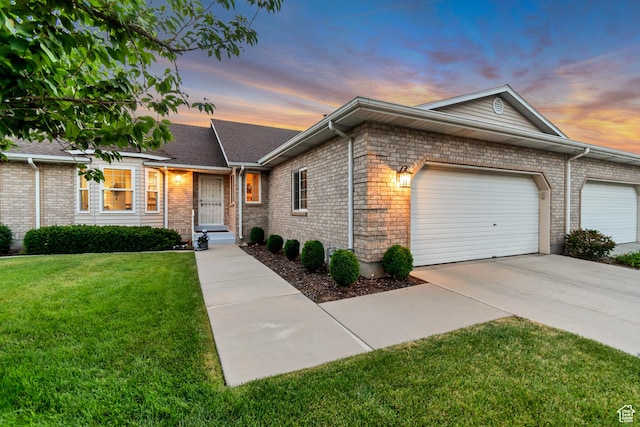 145 N 240 E, Orem, UT 84057 - view of front of house featuring a lawn, a garage, concrete driveway, and brick siding