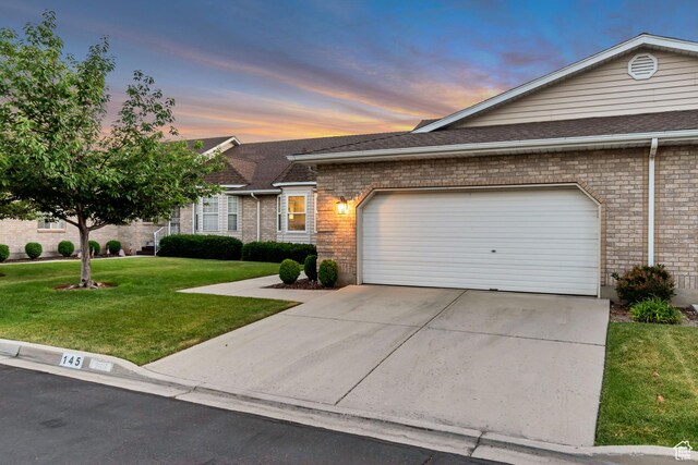 145 N 240 E, Orem, UT 84057 - view of front facade with a front yard, driveway, a garage, brick siding, and roof with shingles
