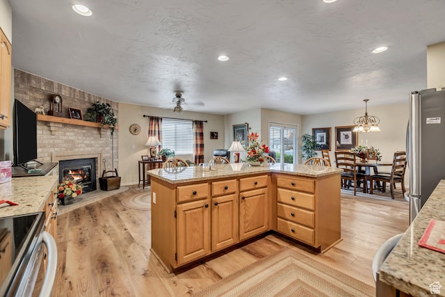 145 N 240 E, Orem, UT 84057 - kitchen featuring stainless steel appliances, light wood-style floors, a fireplace, light stone countertops, and recessed lighting
