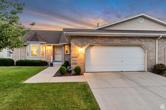 145 N 240 E, Orem, UT 84057 - view of front of house featuring a garage, concrete driveway, a yard, and brick siding