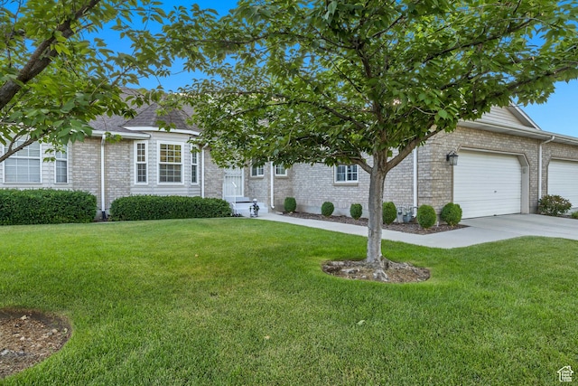 145 N 240 E, Orem, UT 84057 - view of property hidden behind natural elements featuring a front yard, concrete driveway, a garage, and brick siding