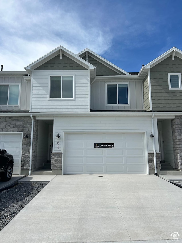 627 W 575 N Unit 545, Smithfield, UT 84335 - view of property featuring stone siding, an attached garage, board and batten siding, and concrete driveway