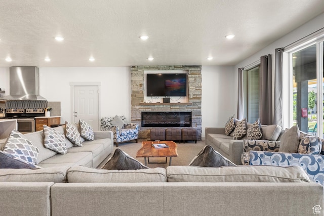 175 S Blue Topaz Ln, Garden City, UT 84028 - carpeted living area with a stone fireplace, recessed lighting, and a textured ceiling