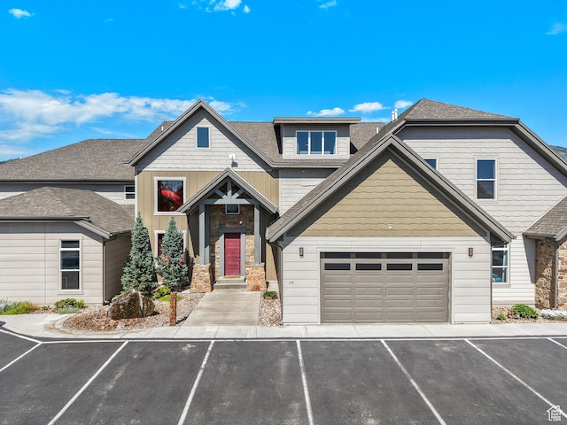 175 S Blue Topaz Ln, Garden City, UT 84028 - view of front of property featuring stone siding, roof with shingles, a garage, and driveway