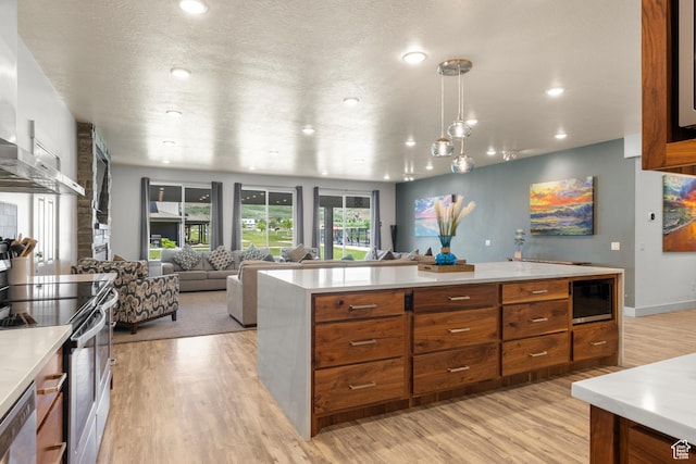 175 S Blue Topaz Ln, Garden City, UT 84028 - kitchen with brown cabinetry, appliances with stainless steel finishes, light wood finished floors, light countertops, and open floor plan