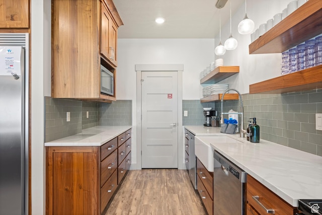 175 S Blue Topaz Ln, Garden City, UT 84028 - kitchen with open shelves, appliances with stainless steel finishes, brown cabinets, light wood-style floors, and decorative backsplash