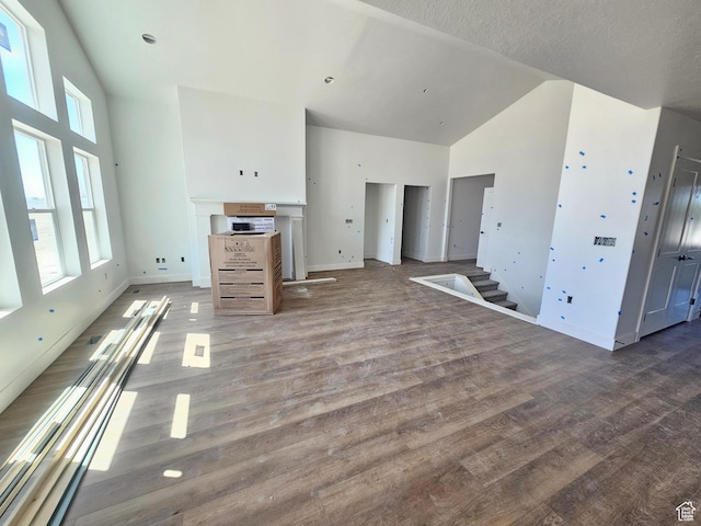 1726 S 3875 W Unit 225, West Weber, UT 84401 - unfurnished living room with high vaulted ceiling, wood finished floors, and stairway