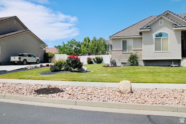 270 Amsterdam Dr, Stansbury Park, UT 84074 - view of front facade featuring stucco siding, a tiled roof, and driveway