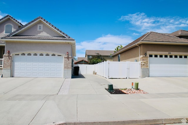 270 Amsterdam Dr, Stansbury Park, UT 84074 - view of property exterior featuring stucco siding, driveway, a garage, and stone siding
