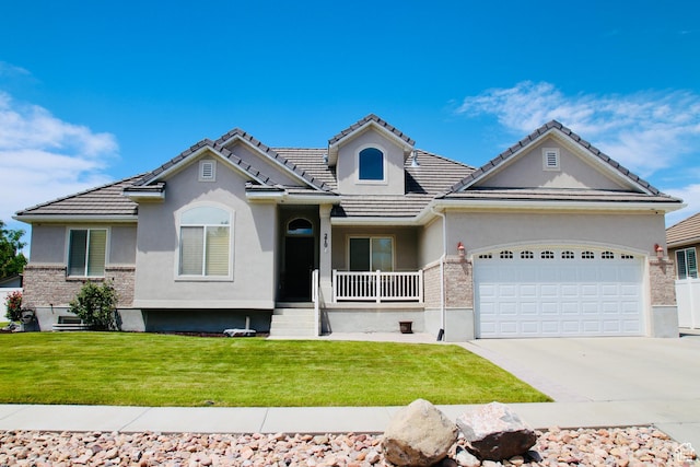 270 Amsterdam Dr, Stansbury Park, UT 84074 - view of front of property with a garage, stucco siding, concrete driveway, covered porch, and a front yard