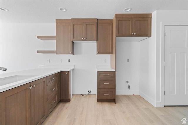 211 W 815 N Unit 19, Nephi, UT 84648 - kitchen featuring light wood-type flooring, open shelves, light countertops, and brown cabinets