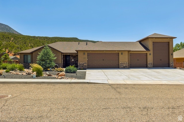 1283 W 1750 S, Cedar City, UT 84720 - view of front of property featuring a garage, stone siding, driveway, and a mountain view