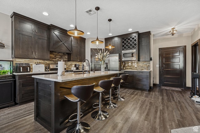 1283 W 1750 S, Cedar City, UT 84720 - kitchen with appliances with stainless steel finishes, light countertops, dark wood-style flooring, a kitchen breakfast bar, and tasteful backsplash