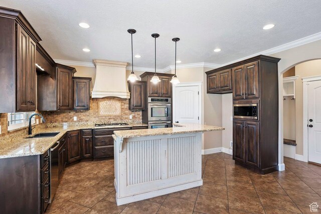 2131 S 1230 W, Syracuse, UT 84075 - kitchen featuring premium range hood, appliances with stainless steel finishes, dark brown cabinets, arched walkways, and recessed lighting
