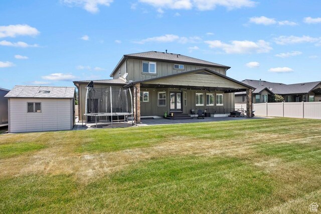 2131 S 1230 W, Syracuse, UT 84075 - back of property featuring a trampoline, a patio, board and batten siding, an outbuilding, and entry steps