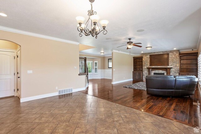 2131 S 1230 W, Syracuse, UT 84075 - living room featuring a ceiling fan, a stone fireplace, ornamental molding, a chandelier, and arched walkways