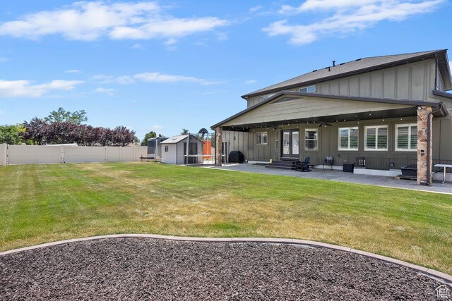 2131 S 1230 W, Syracuse, UT 84075 - back of house with board and batten siding, a patio, a shed, a fenced backyard, and entry steps