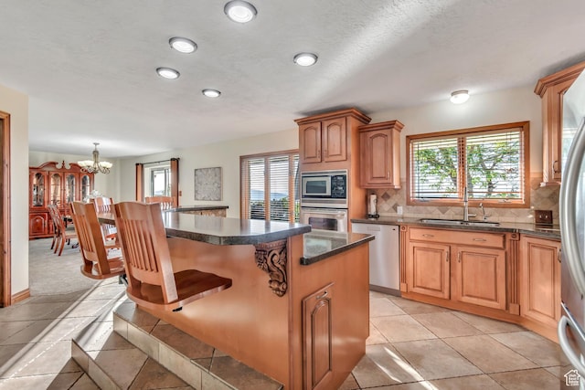 685 S Woodland Hills Dr, Woodland Hills, UT 84653 - kitchen featuring appliances with stainless steel finishes, a kitchen breakfast bar, decorative backsplash, a kitchen island, and a chandelier
