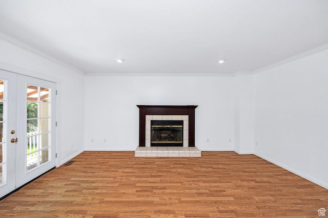 672 E Center St, Providence, UT 84332 - unfurnished living room featuring ornamental molding, light wood-style floors, a tiled fireplace, recessed lighting, and french doors
