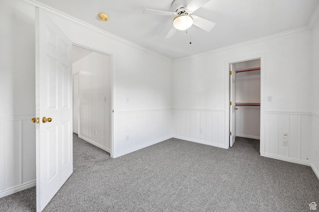 672 E Center St, Providence, UT 84332 - unfurnished bedroom with carpet flooring, a wainscoted wall, a walk in closet, ornamental molding, and a ceiling fan