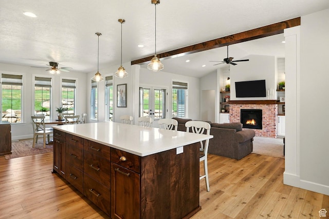 13189 N Brookside Dr, Garland, UT 84312 - kitchen featuring ceiling fan, a breakfast bar, french doors, a brick fireplace, and recessed lighting