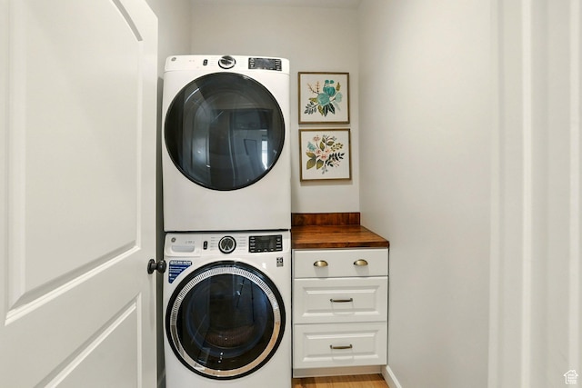 13189 N Brookside Dr, Garland, UT 84312 - washroom with stacked washer and clothes dryer, cabinet space, and light wood-style flooring