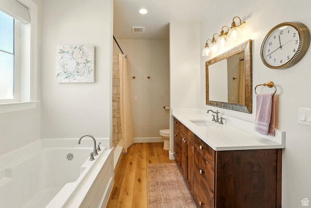 13189 N Brookside Dr, Garland, UT 84312 - full bathroom featuring a garden tub, vanity, wood finished floors, curtained shower, and recessed lighting