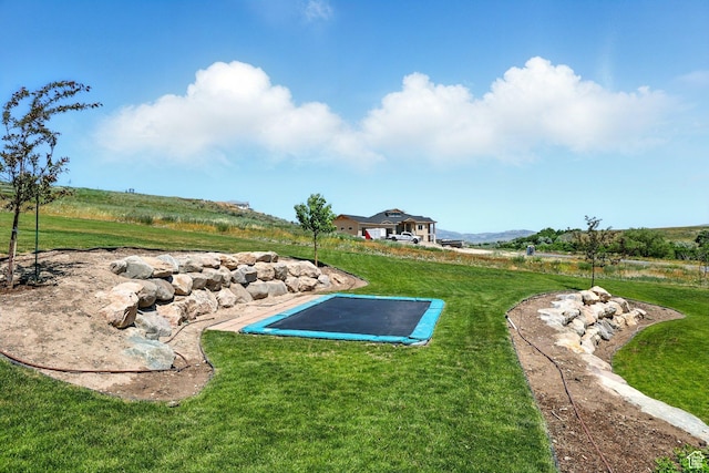13189 N Brookside Dr, Garland, UT 84312 - view of green lawn featuring a trampoline