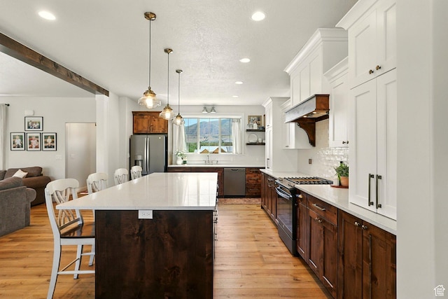 13189 N Brookside Dr, Garland, UT 84312 - kitchen featuring appliances with stainless steel finishes, a kitchen breakfast bar, recessed lighting, light countertops, and light wood finished floors