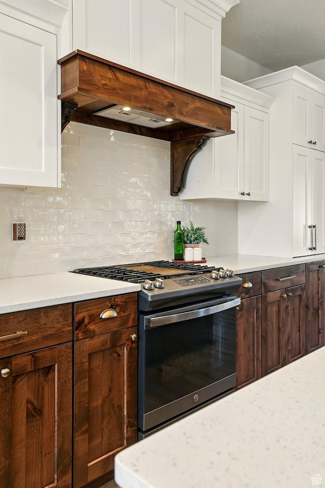 13189 N Brookside Dr, Garland, UT 84312 - kitchen featuring stainless steel gas range oven, light countertops, premium range hood, and white cabinets