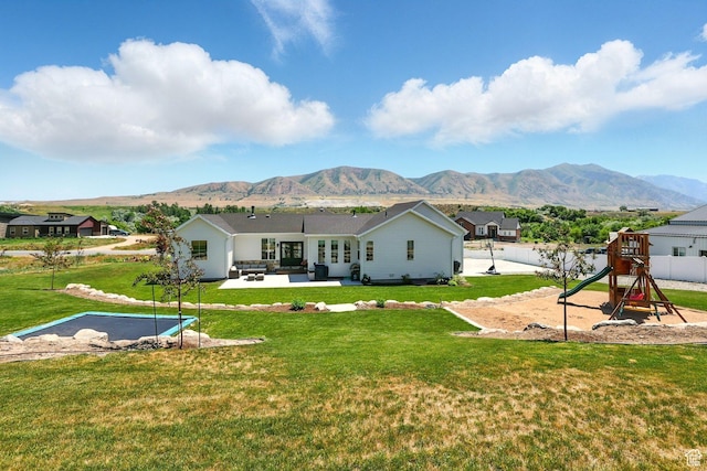 13189 N Brookside Dr, Garland, UT 84312 - rear view of house featuring a playground, a mountain view, a patio area, and an outdoor living space