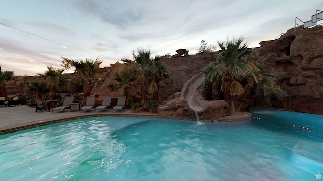 4582 S 1500 W, Hurricane, UT 84737 - pool at dusk featuring a water slide, a patio area, and an outdoor pool