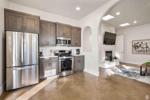 4582 S 1500 W, Hurricane, UT 84737 - kitchen featuring stainless steel appliances, arched walkways, decorative backsplash, light countertops, and dark brown cabinetry
