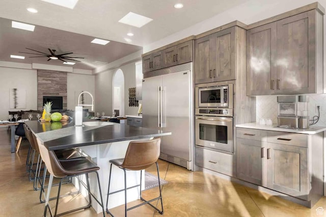 4582 S 1500 W, Hurricane, UT 84737 - kitchen featuring built in appliances, arched walkways, decorative backsplash, open floor plan, and a ceiling fan