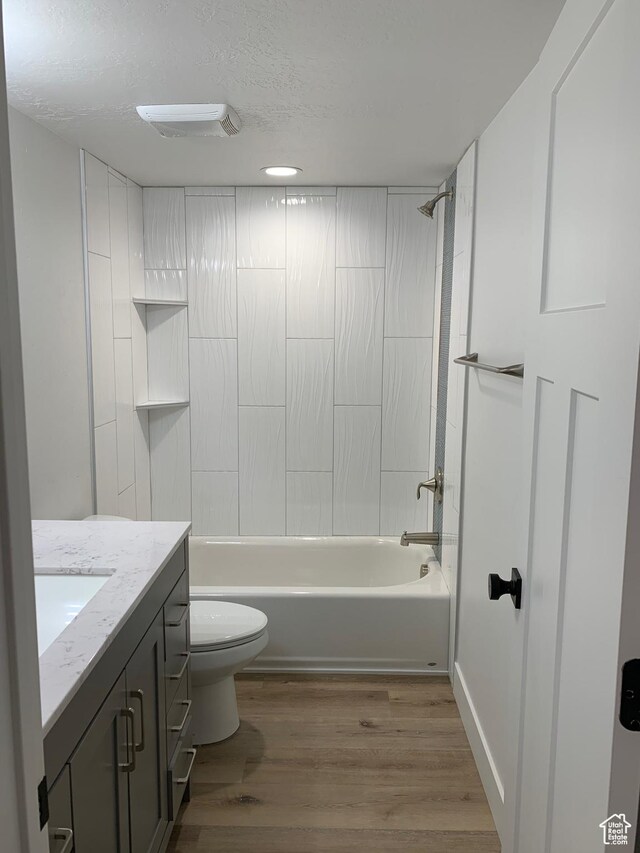 575 40th St, Ogden, UT 84403 - bathroom featuring vanity, wood finished floors, bathing tub / shower combination, and a textured ceiling