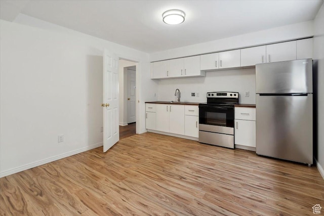 3181 E Deer Creek Cir, Cottonwood Heights, UT 84121 - kitchen featuring stainless steel appliances, dark countertops, light wood-type flooring, and white cabinetry