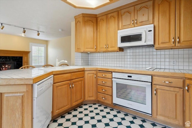 3181 E Deer Creek Cir, Cottonwood Heights, UT 84121 - kitchen with white appliances, a peninsula, tile patterned floors, tile counters, and backsplash