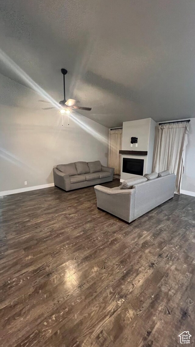 539 S Chan Dr, Grantsville, UT 84029 - living room with dark wood-type flooring, a ceiling fan, a textured ceiling, and a fireplace