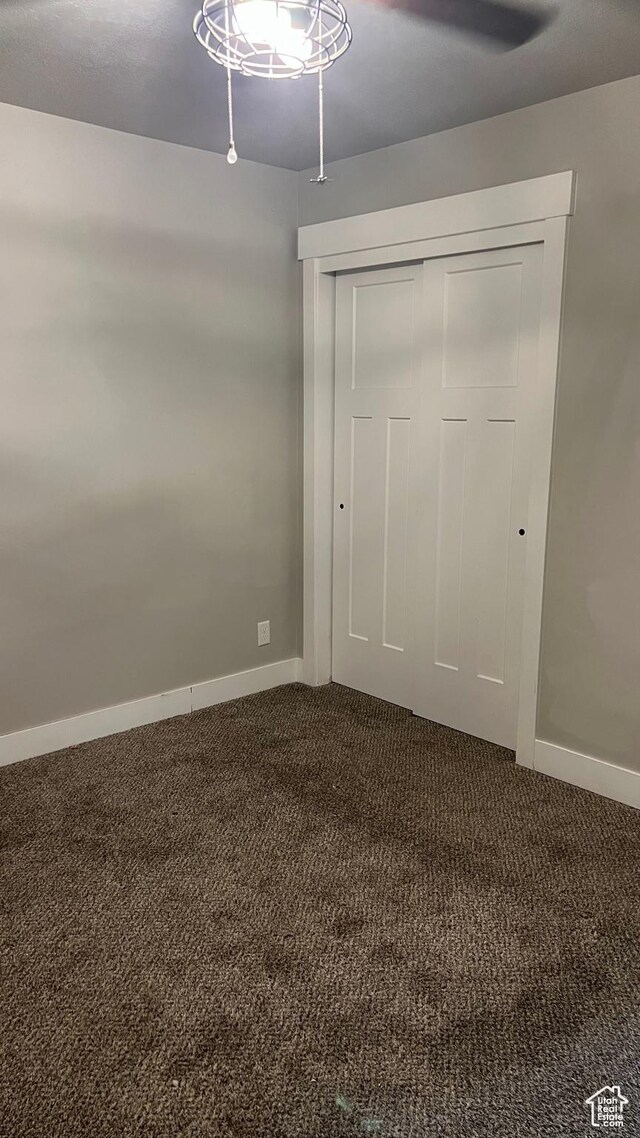 539 S Chan Dr, Grantsville, UT 84029 - unfurnished bedroom with dark carpet, a closet, and ceiling fan