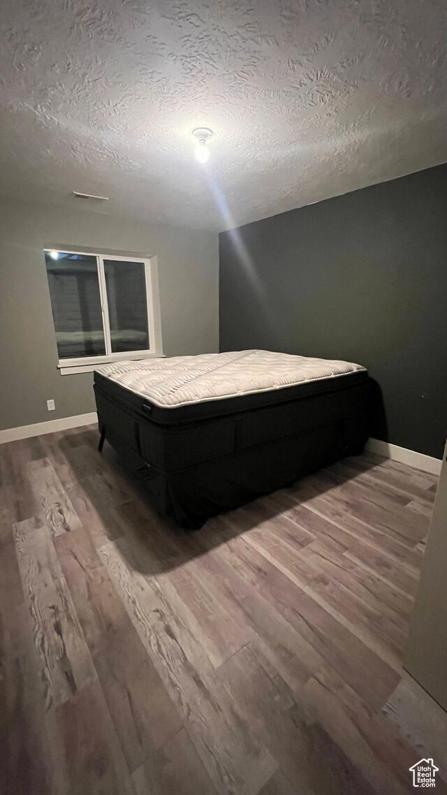 539 S Chan Dr, Grantsville, UT 84029 - bedroom featuring wood finished floors and a textured ceiling