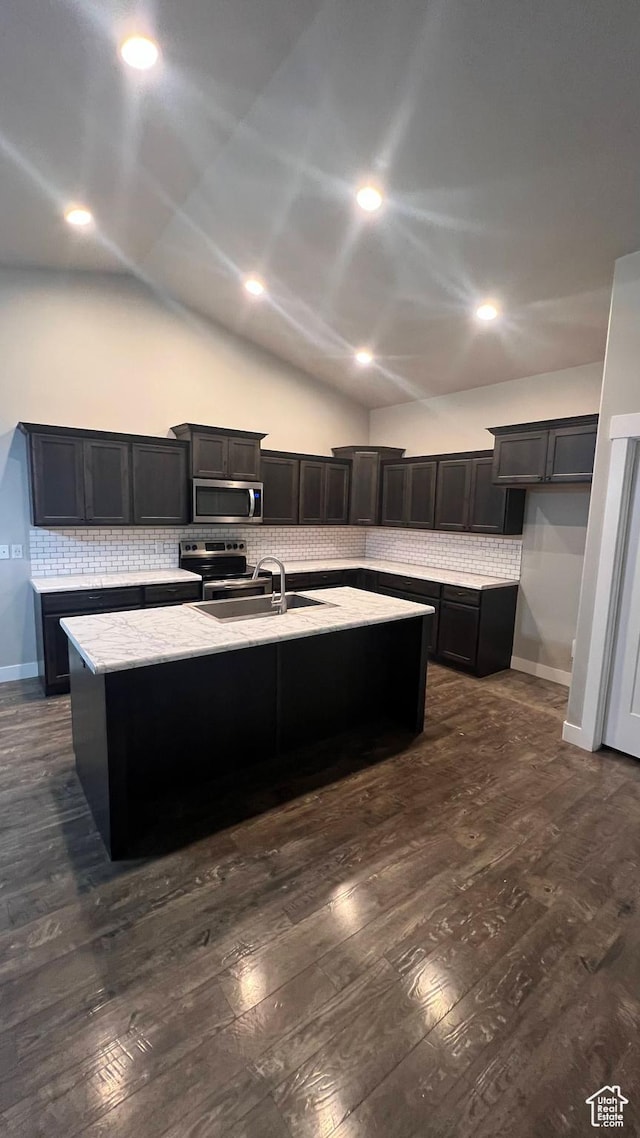 539 S Chan Dr, Grantsville, UT 84029 - kitchen featuring appliances with stainless steel finishes, dark wood-style floors, decorative backsplash, an island with sink, and lofted ceiling