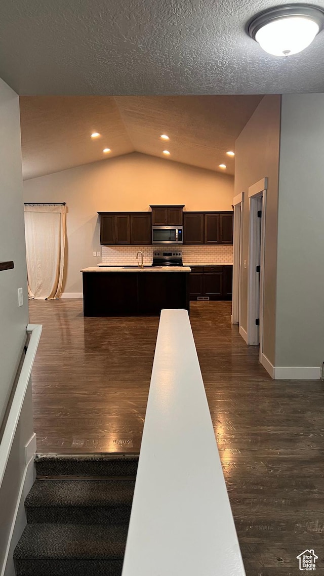 539 S Chan Dr, Grantsville, UT 84029 - kitchen featuring appliances with stainless steel finishes, lofted ceiling, dark wood finished floors, dark brown cabinetry, and a textured ceiling